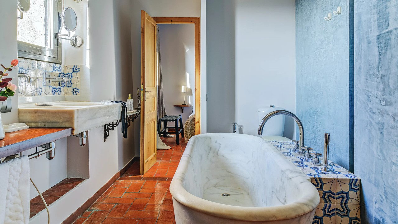 Baño con bañera exenta y azulejos artesanales en la Masia de Queralt