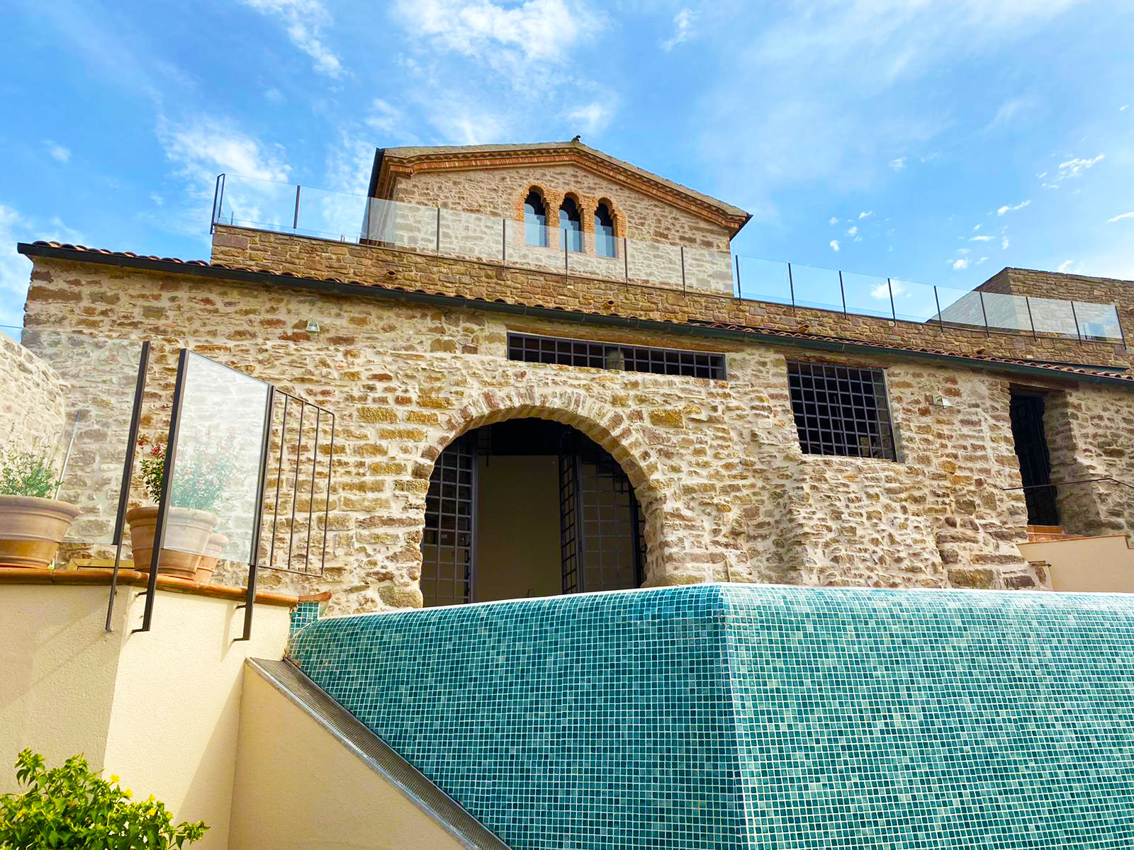 Piscina de la Masia de Queralt junto a la fachada de piedra