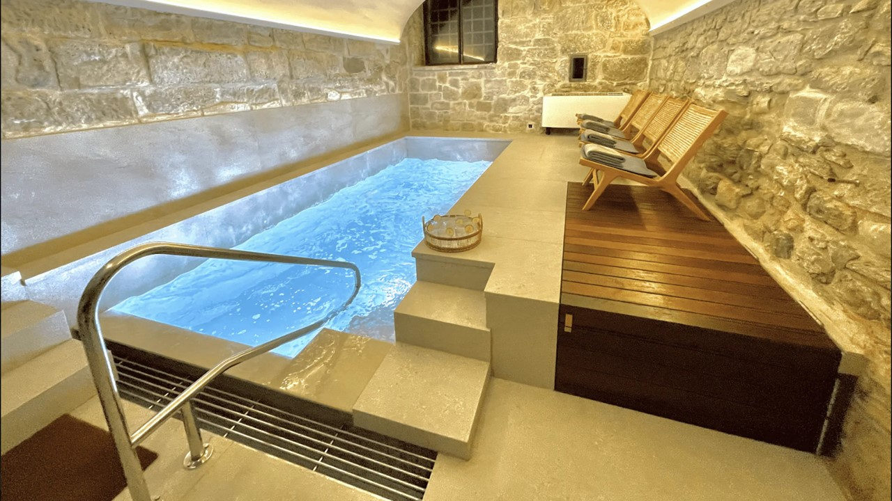 Spa de la Masia de Queralt con piscina interior entre muros de piedra