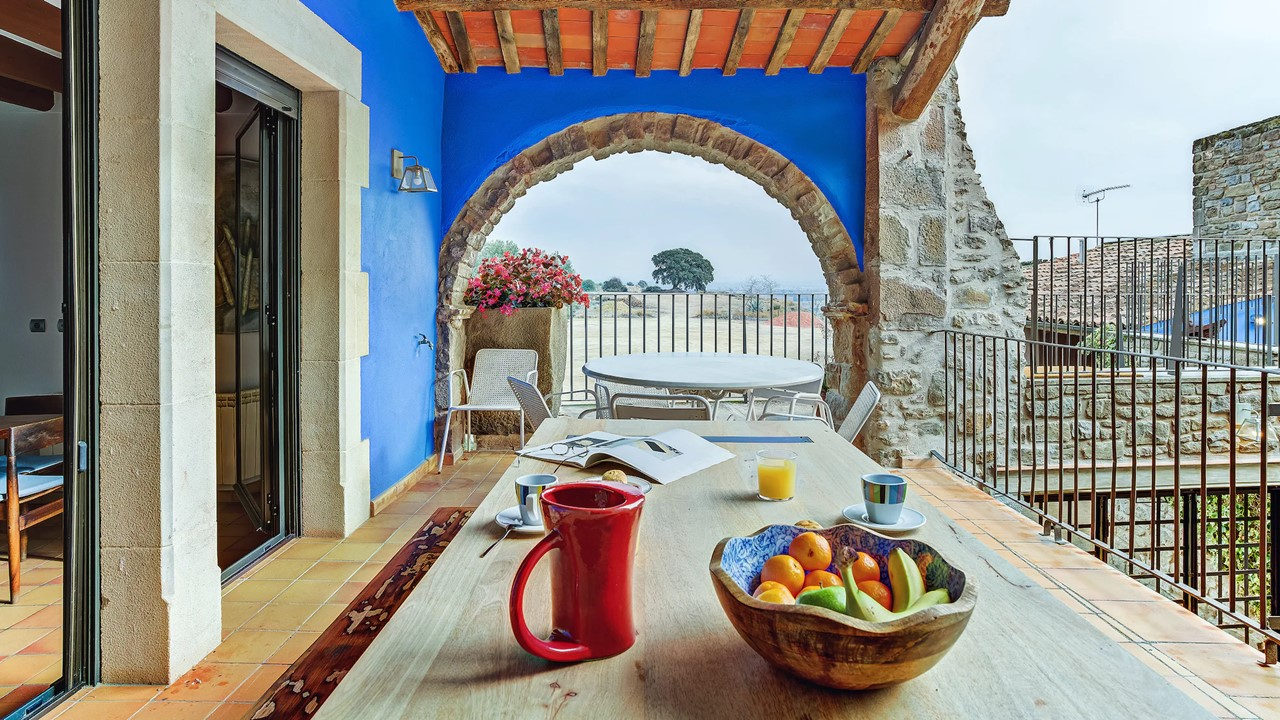 Desayuno en la terraza con arco de piedra de la Masia de Queralt