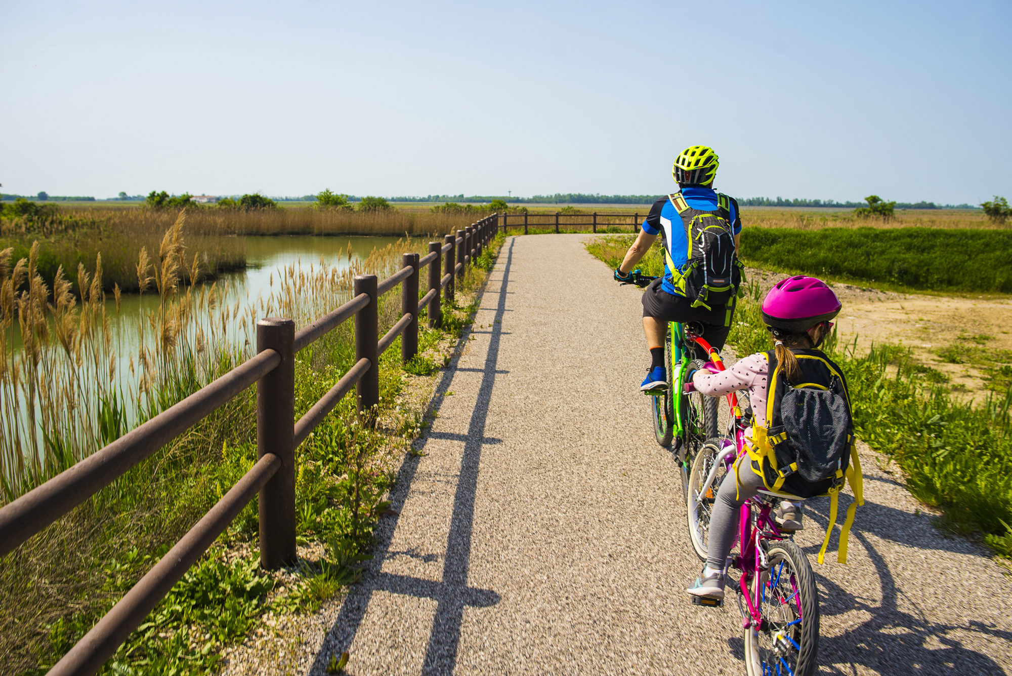 Ruta en bicicleta en familia por un camino entre humedales