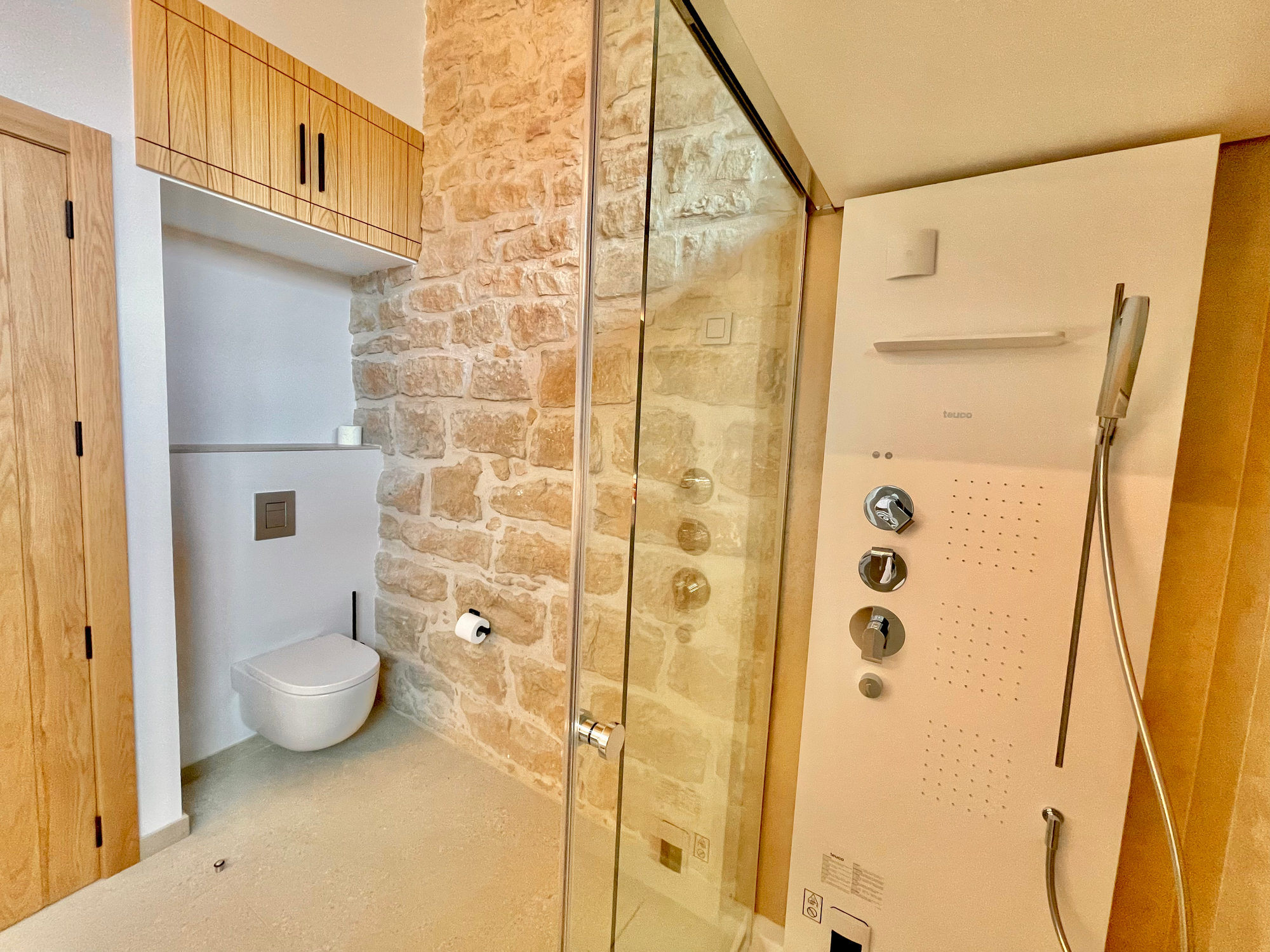 Baño de la Torre de Queralt con ducha y pared de piedra