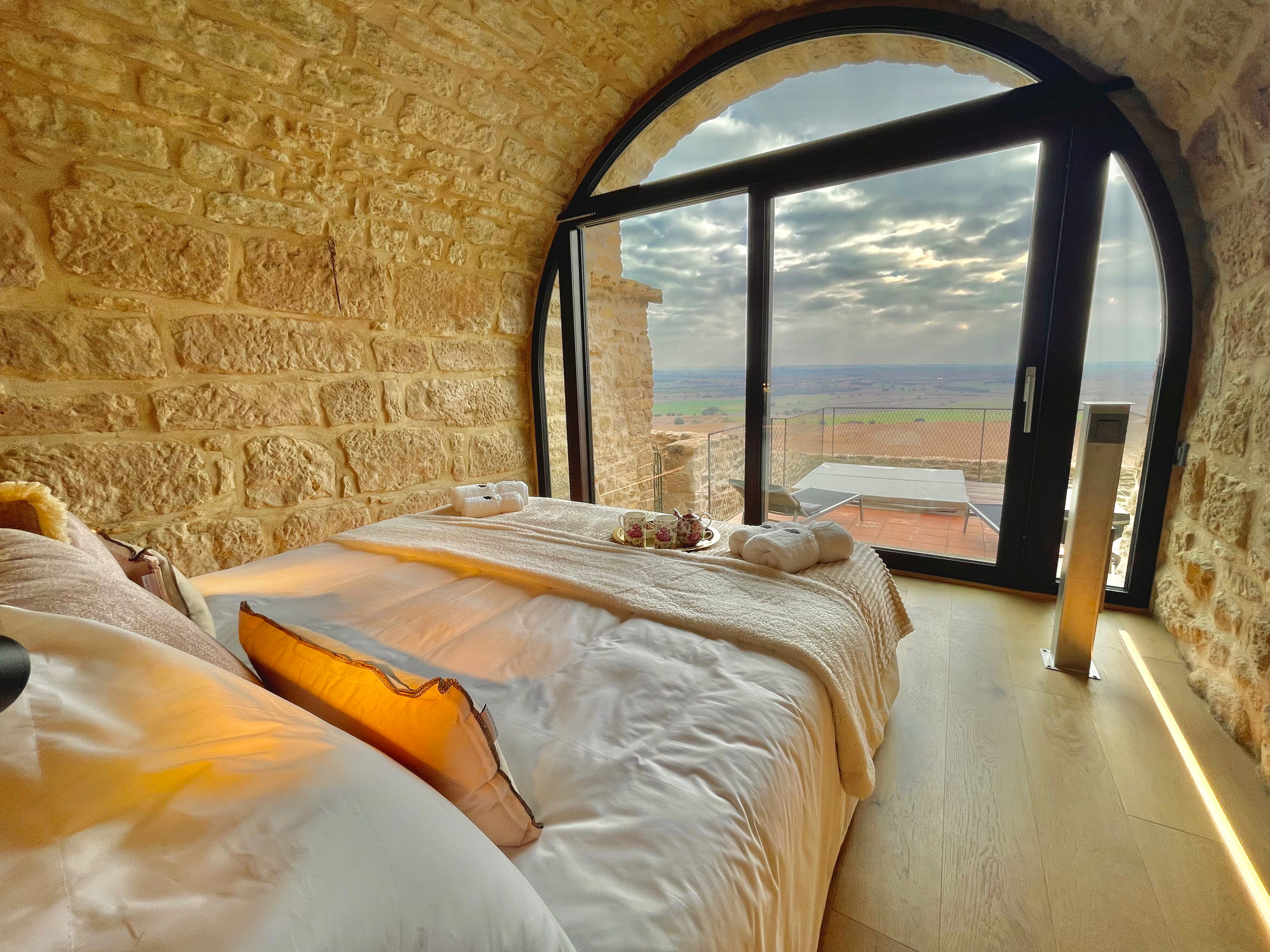 Dormitorio de la Torre de Queralt con ventanal en arco y vistas a la Segarra